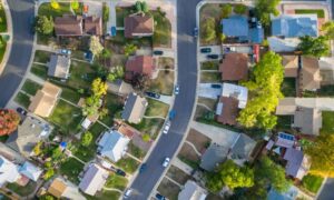 Aerial view of a residential neighborhood with homes, driveways, streets, and individual property lots, representing a property setting for a loan closing survey